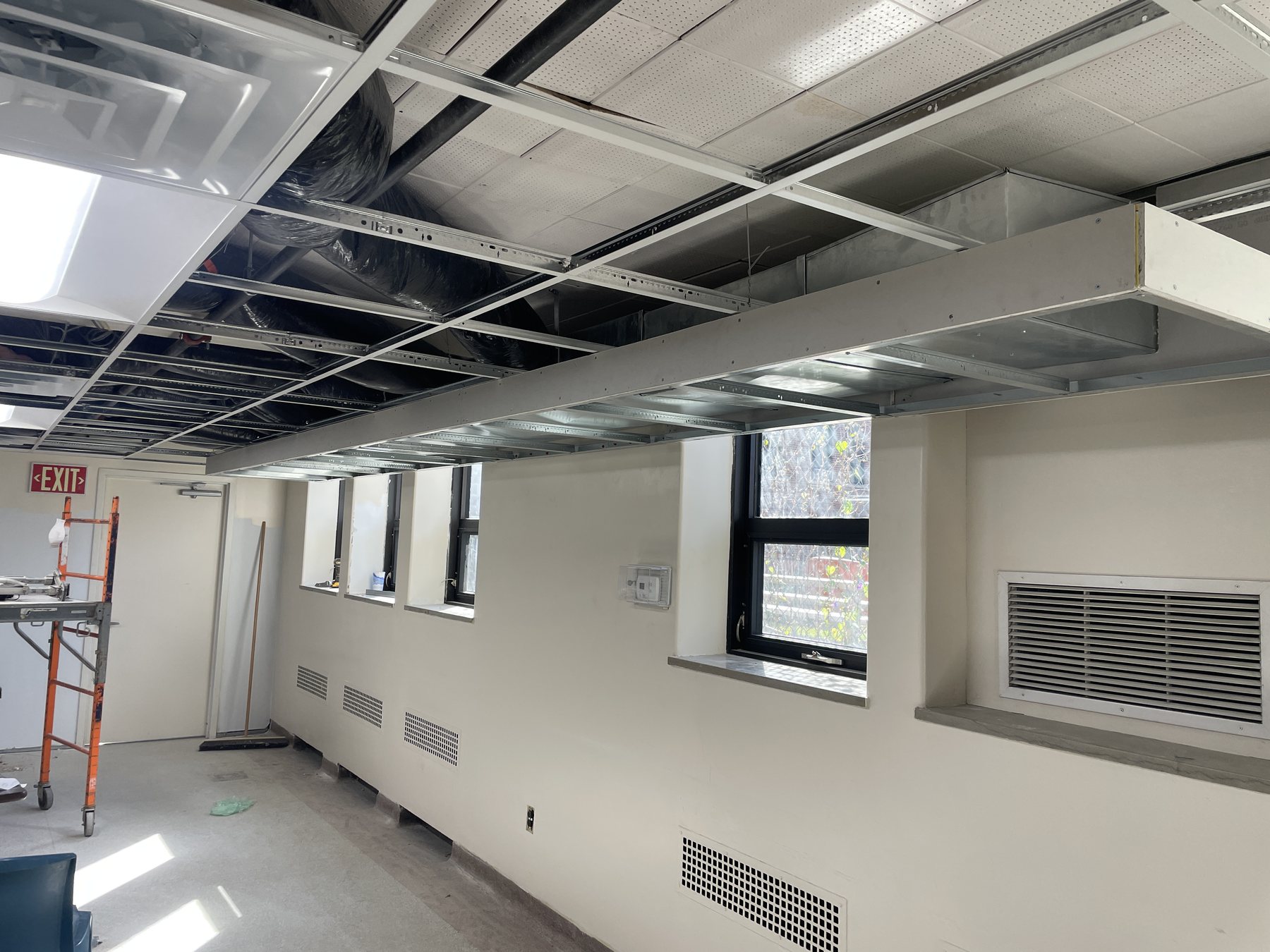 Bulkhead transition framed around mechanical ductwork within a commercial suspended ceiling