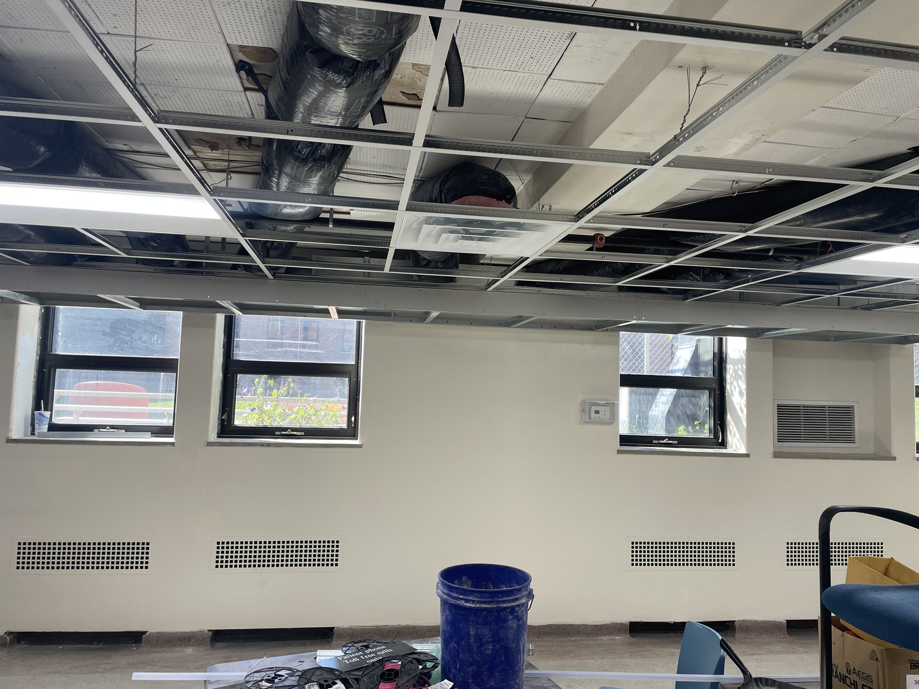 Wide view of a commercial ceiling grid meeting a bulkhead transition during installation