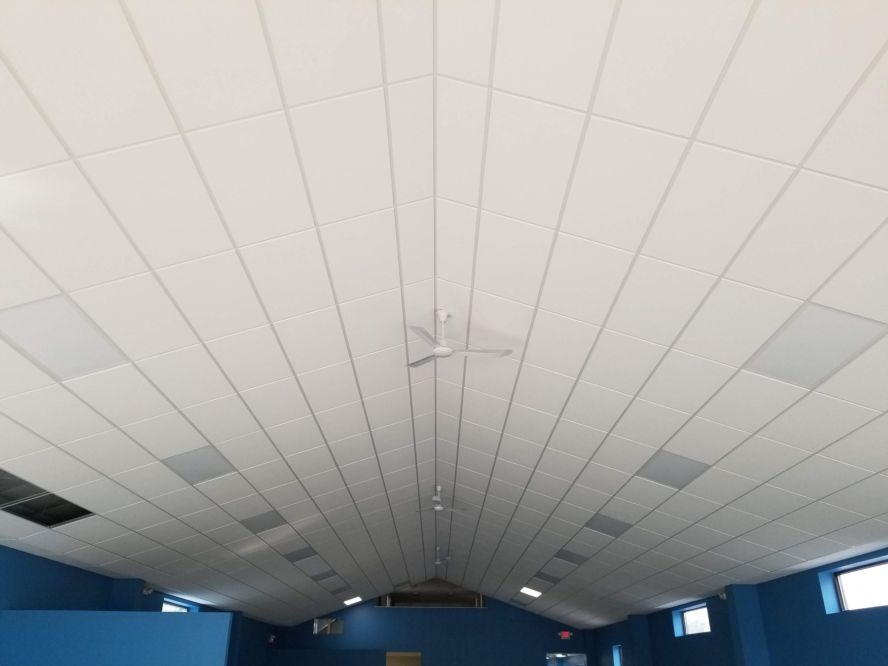 Finished ceiling panels meeting at the center ridge of a vaulted ceiling